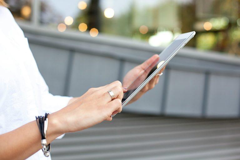 un apprenant tient une tablette pour suivre la formation DEAES