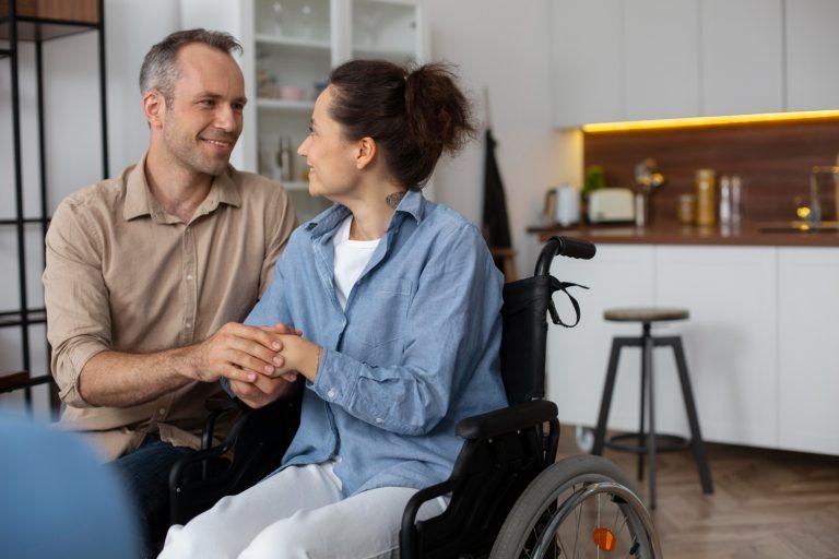 Un homme et une femme sont dans une cuisine. La femme est dans un fauteuil roulant. Ils ont droit au logement adapté © Freepik